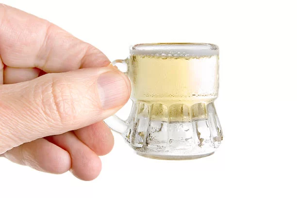 a hand holding a small mug of something